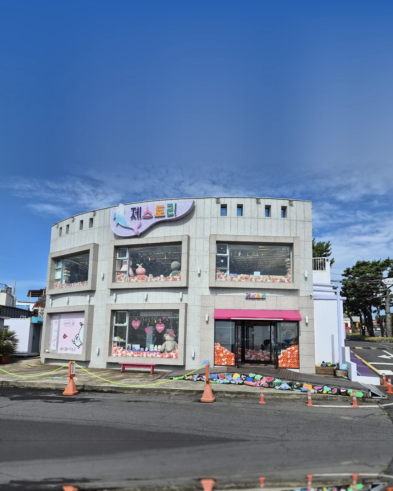 분홍 차양이 걸린 법환포구 앞 제스토리 매장 외관